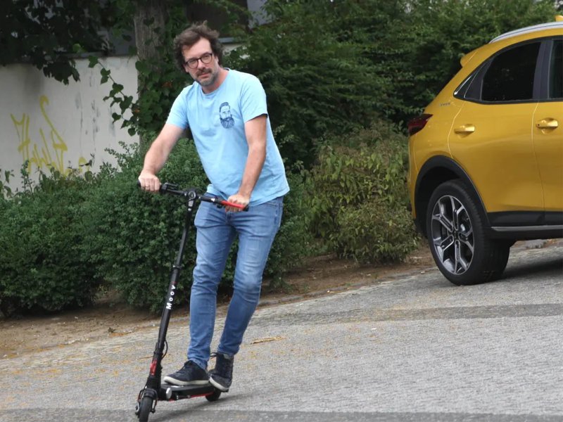Regeln-E-Scooter-2027.jpg Ein Mann fährt mit einem E-Roller auf der Straße.